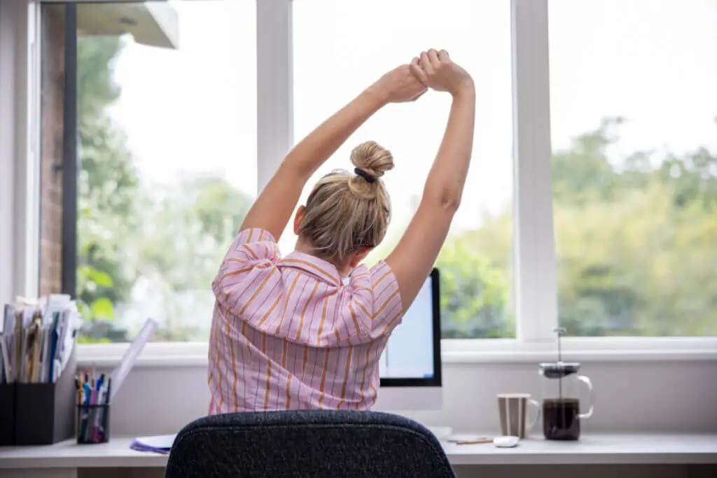 Rear View Of Woman Working From Home On Computer In Home Office